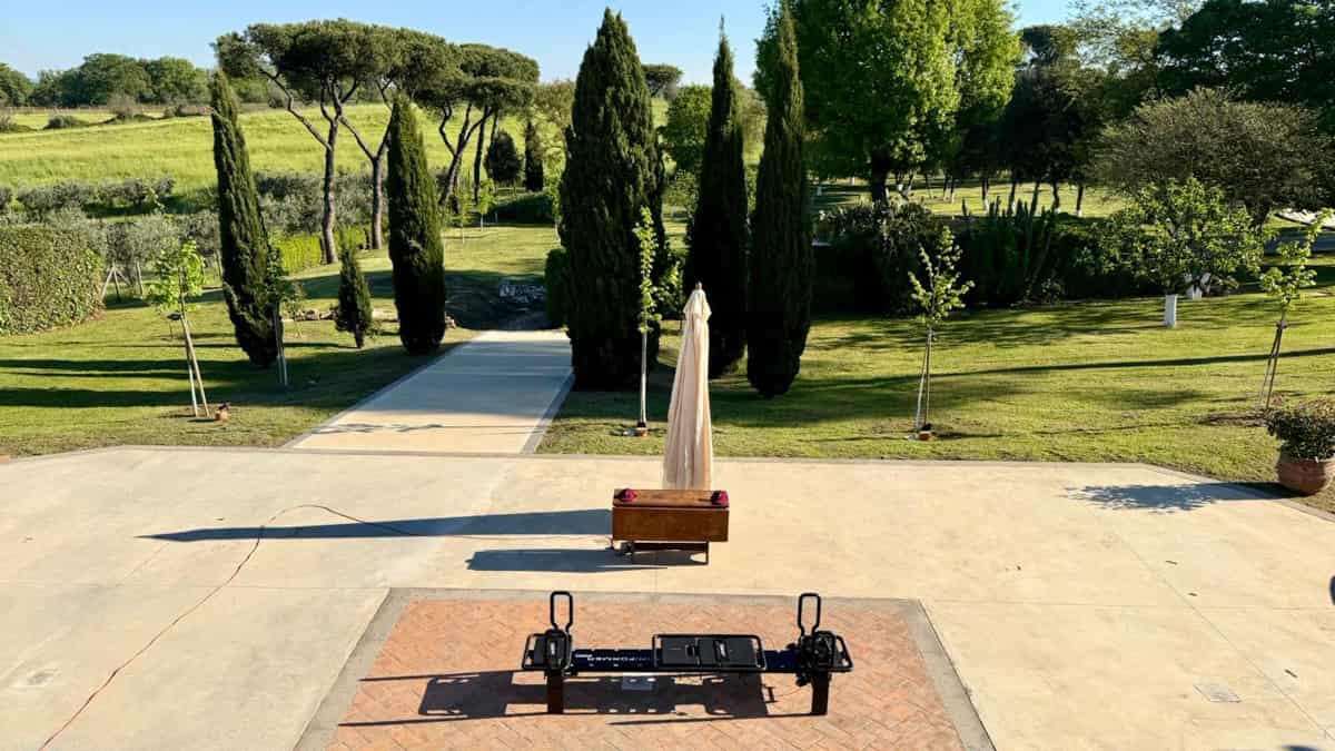 La tenuta immersa nel verde di Club33 a Roma, con un Megaformer all'aperto tra i cipressi