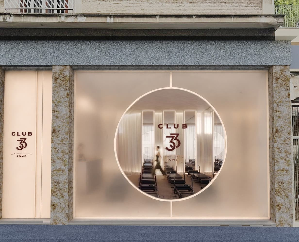 La futura vetrina dello studio Club33 ai Parioli: vetro satinato con un grande oblò al centro, da cui si vede la sala con i Megaformer